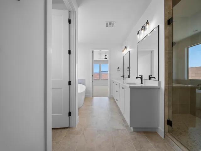 Dual vanity with white cabinetry, matte black fixtures, and framed mirrors
