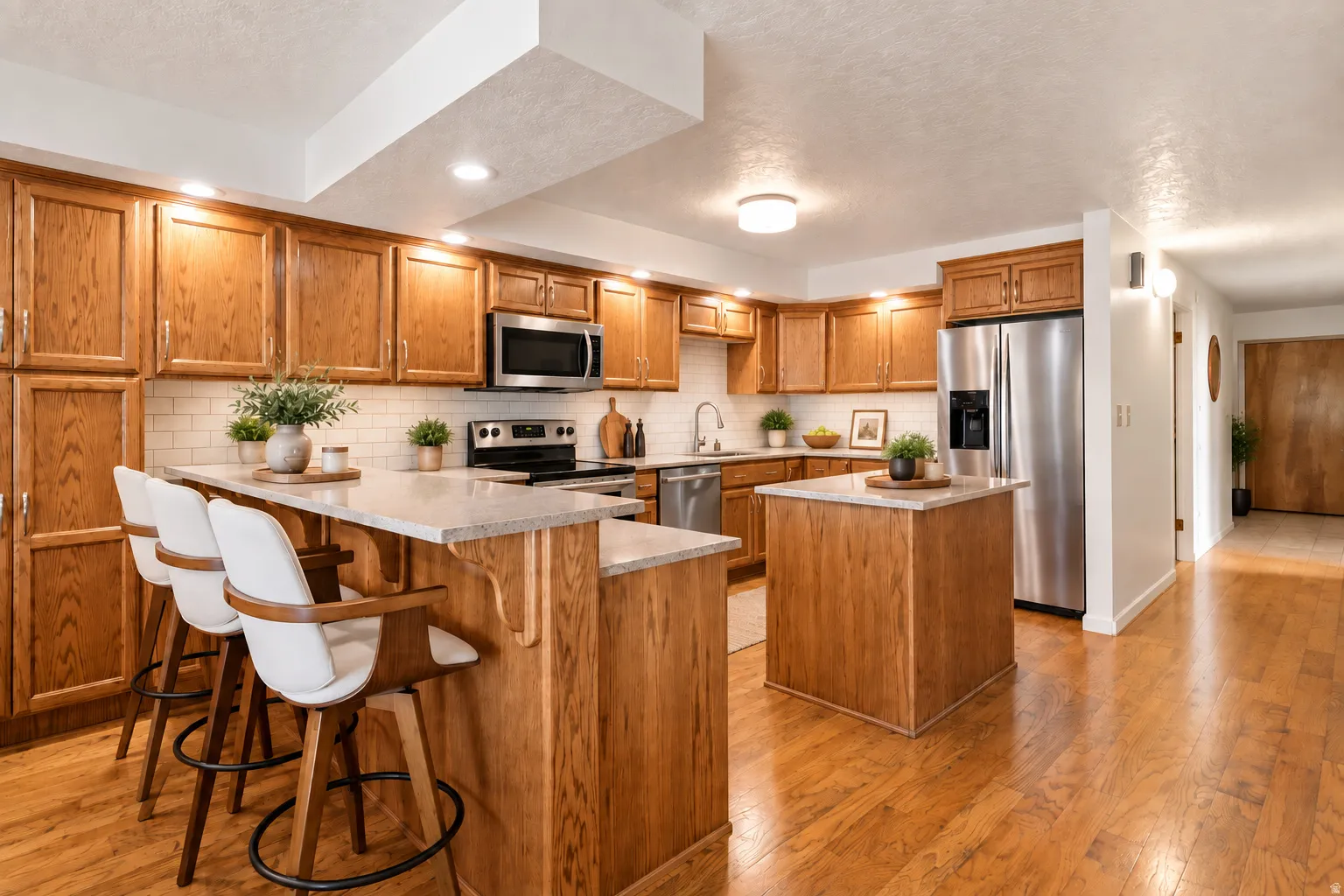 Kitchen featuring wood cabinetry, stainless steel appliances, a white subway tile backsplash, and a central island with a breakfast bar