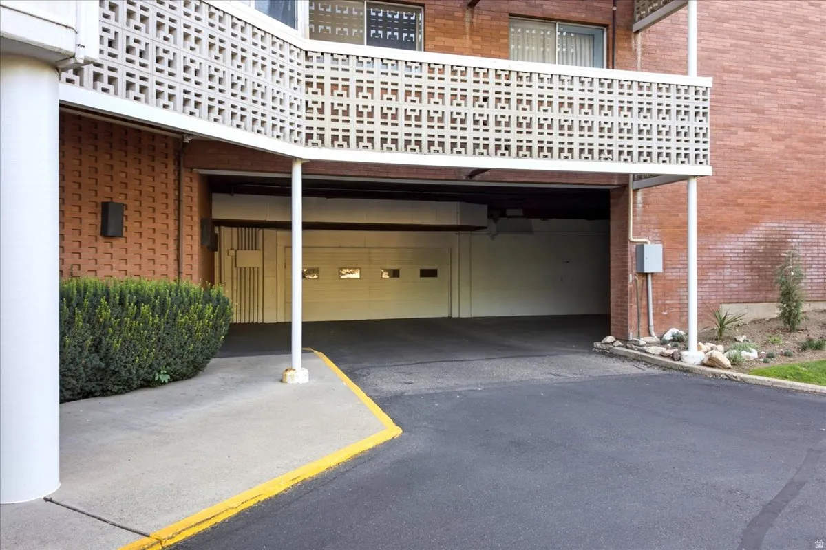 Covered parking access with a garage door and brick exterior