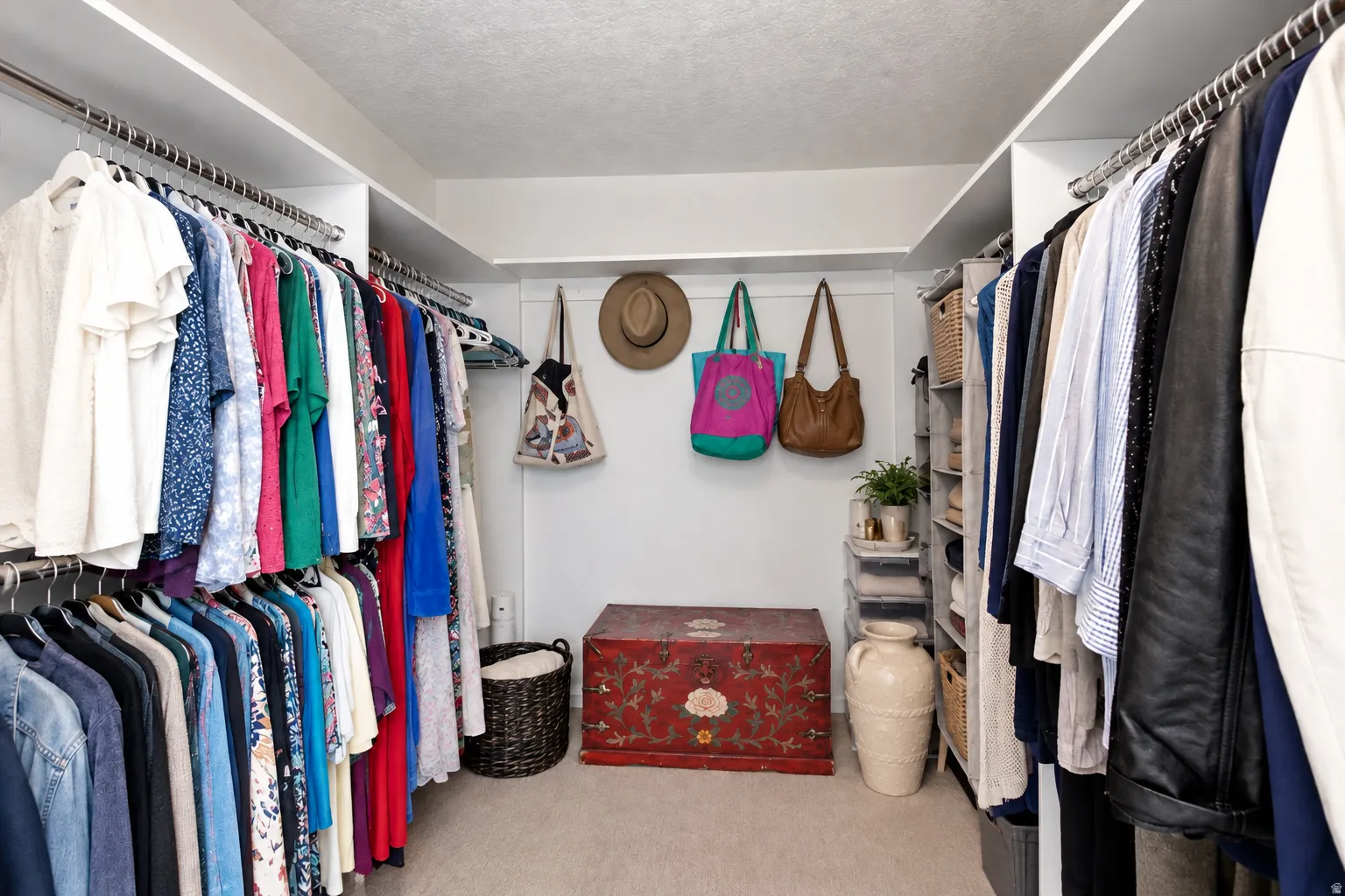 Built-in closet system with multiple hanging rods, overhead shelving, and carpeted flooring