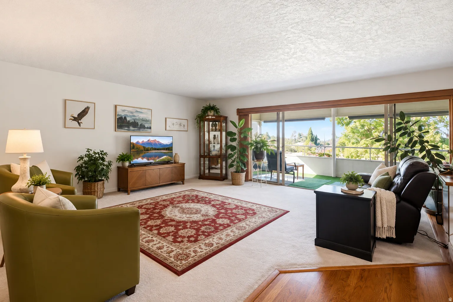 Spacious living area featuring light-colored carpeting, a step-down entry with wood-finish flooring, and white wall finishes