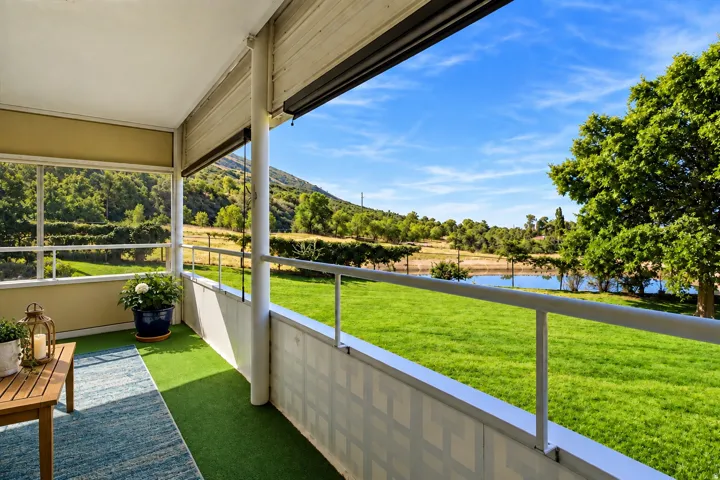 Enclosed balcony with faux turf flooring and white railing