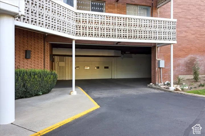 Covered parking access with a garage door and brick exterior