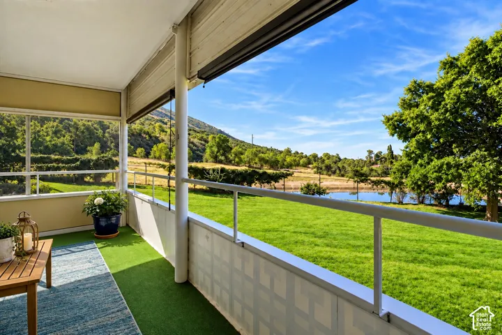 Enclosed balcony with faux turf flooring and white railing