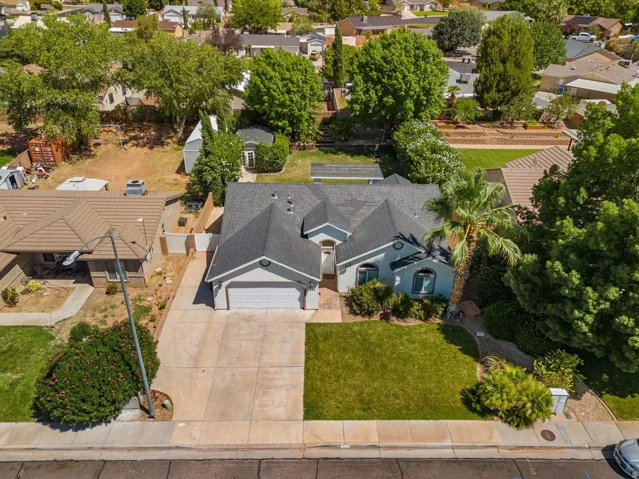 Single-story residence featuring a two-car garage, front lawn, and mature landscaping