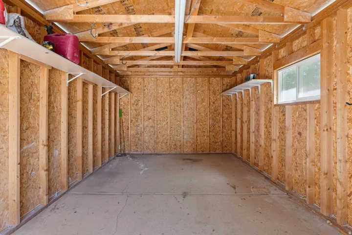 Concrete flooring, exposed wood framing, built-in shelving, and a single-pane window