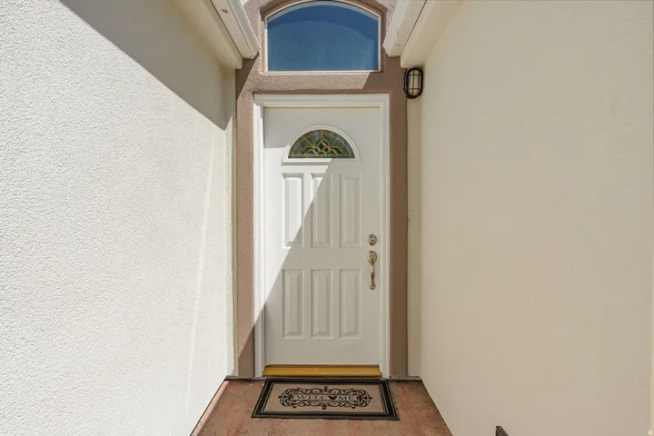 Arched transom window above a paneled front door with decorative glass