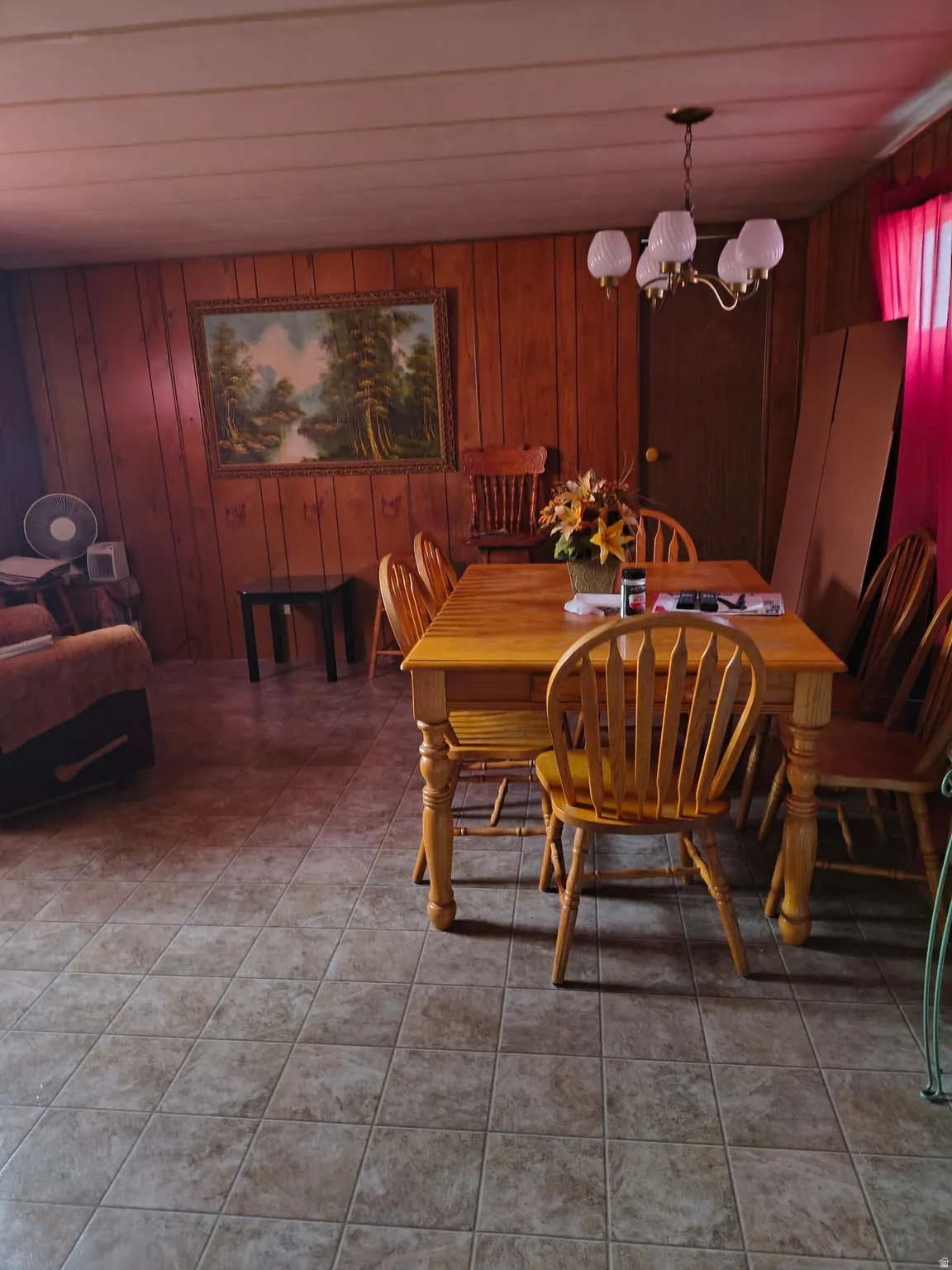 Paneling walls, suspended lighting fixture, and square tile flooring