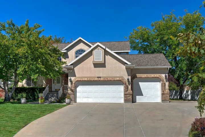 Stucco exterior with brick accents, featuring an arched window and covered entry