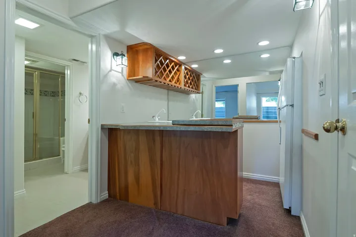 Wet bar with wood cabinetry and countertop