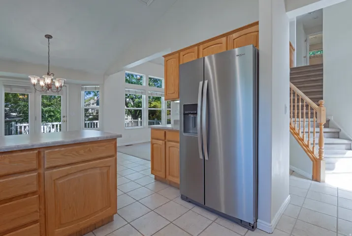 Kitchen featuring wood cabinetry, stainless steel refrigerator, and tile flooring