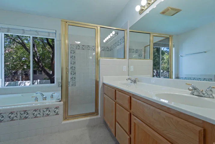 Dual basin vanity with wood-finish cabinetry and chrome fixtures