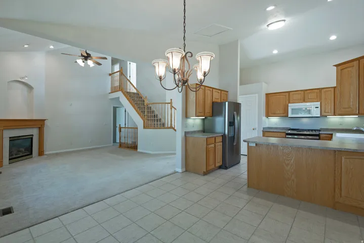 Kitchen with wood cabinetry, stainless steel appliances, and tile flooring