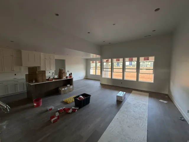 Open-concept living area with wood-finish flooring, recessed lighting, and multiple windows