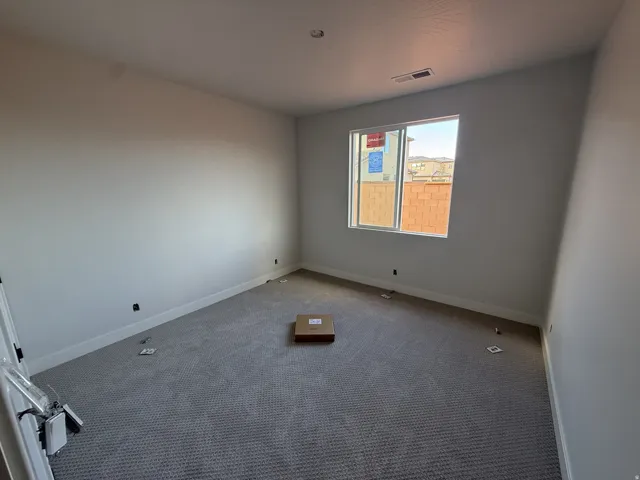 Carpeted room with a single window, white walls, and white trim