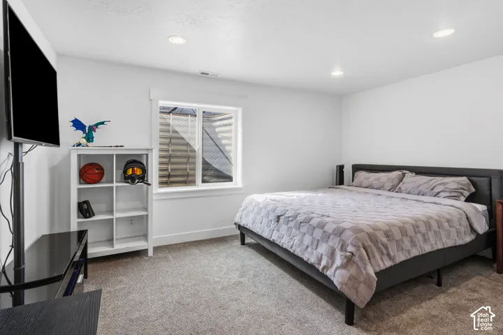 Recessed lighting illuminates neutral-toned walls and plush carpet flooring