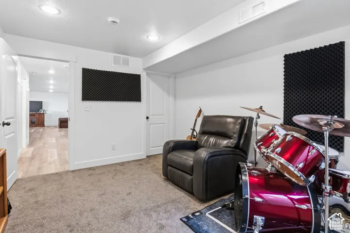 Carpeted bonus room with recessed lighting and acoustic wall panels
