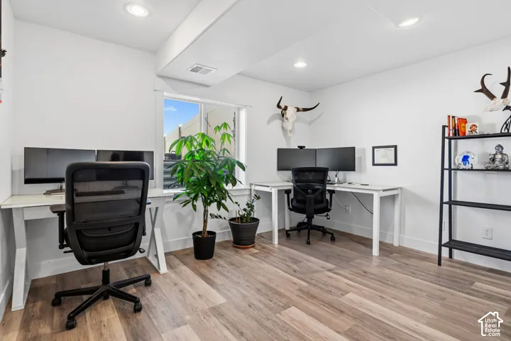 Recessed lighting, wood-finish flooring, and white walls