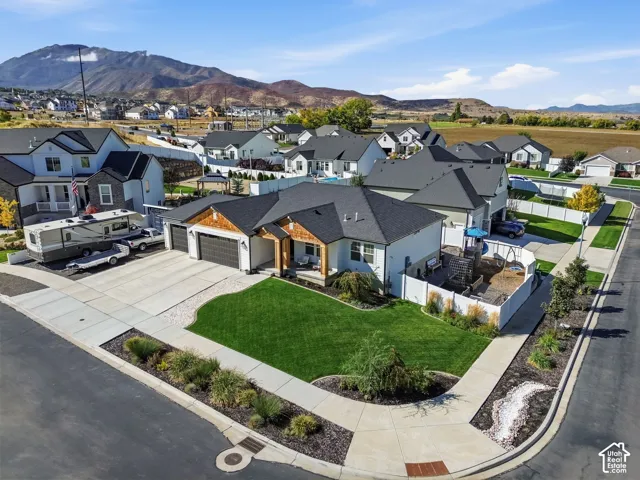 Corner lot with a manicured front lawn, landscaped beds, an attached two-car garage, and a covered porch entry
