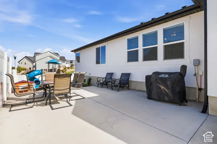 Expansive concrete patio with white exterior siding and multiple windows