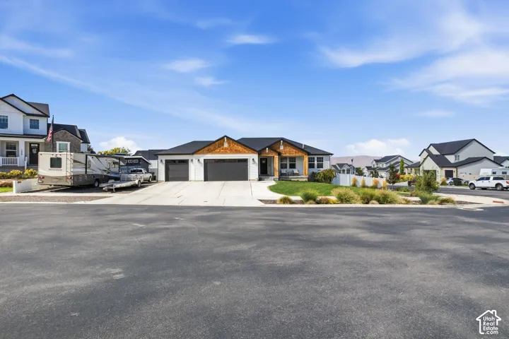 Contemporary exterior with a two-car garage, white siding, and dark trim