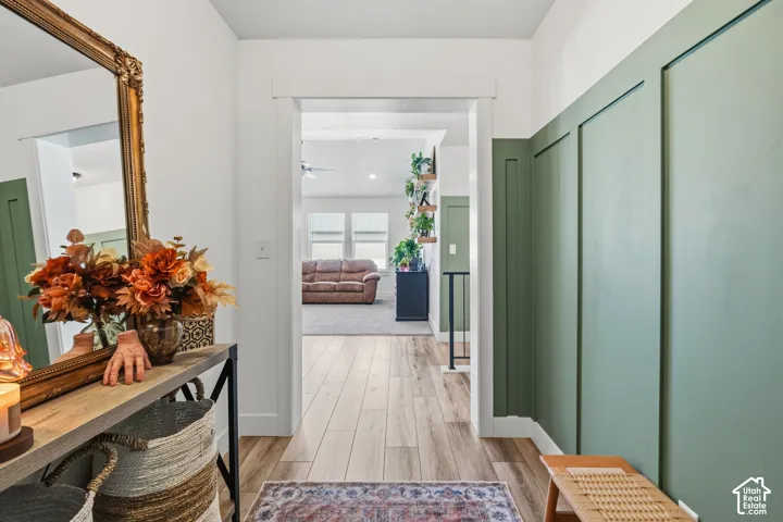 Entryway featuring wood-finish flooring, a decorative panel accent wall, and an arched doorway