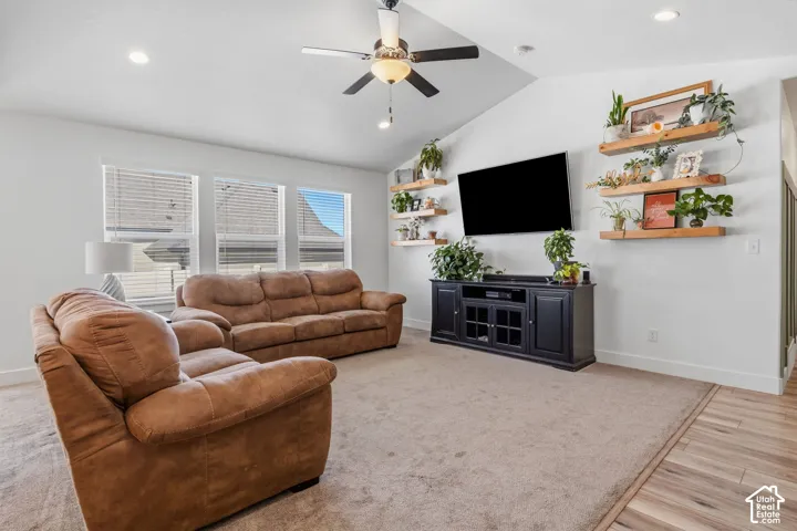 Vaulted ceiling with a ceiling fan, recessed lighting, multiple windows with blinds, and wood-finish flooring