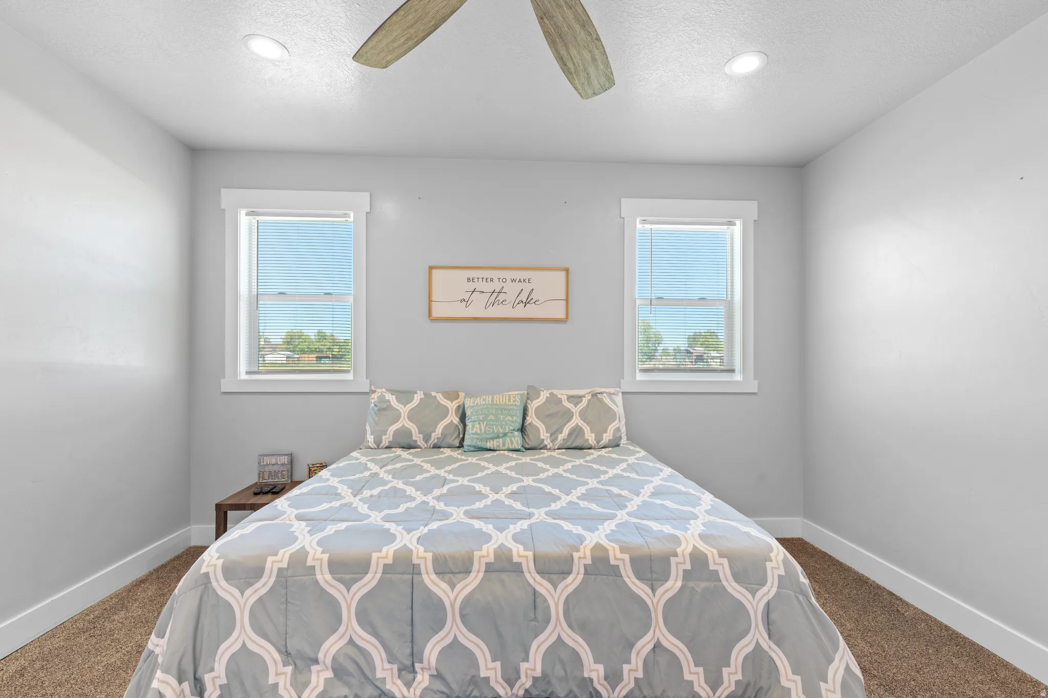 Two windows with white trim, recessed lighting, and a ceiling fan