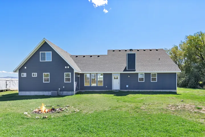 Expansive green lawn with a stone-lined fire pit
