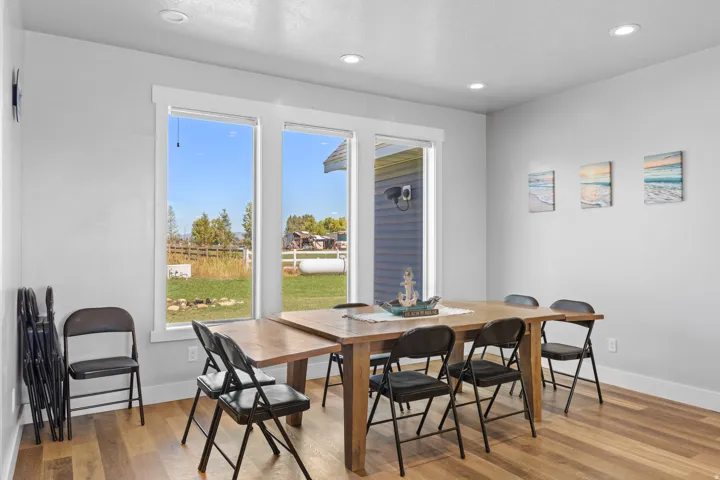 Recessed lighting, wood-finish flooring, white trim, multiple windows, and light gray wall paint