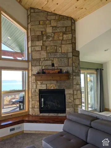 Stone-clad fireplace with a wood mantel, integrated fireplace insert, and stone hearth