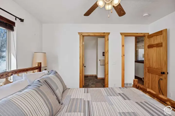Wood-framed doorways, wooden ceiling fan with integrated lighting, and natural wood door
