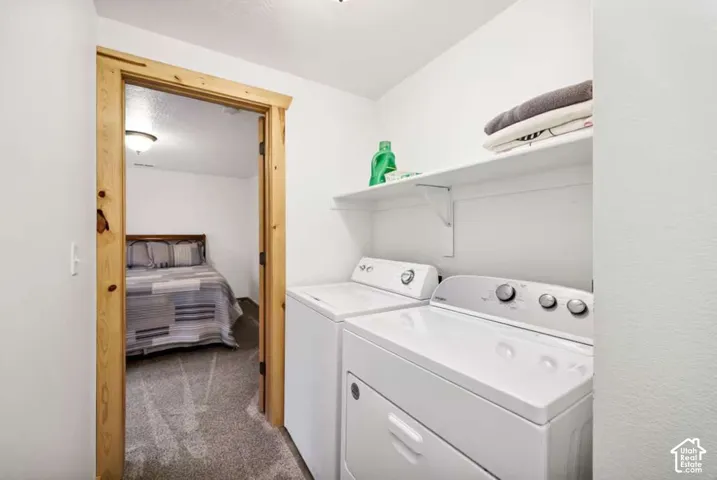 Dedicated laundry area with white appliances and built-in shelving