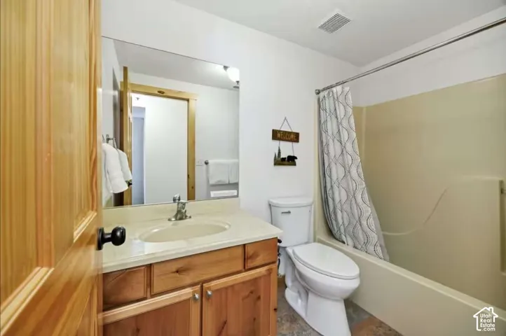 Wood-finish door, vanity with integrated sink, chrome faucet, wall-mounted mirror, and a bathtub with shower
