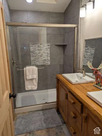 Shower with sliding glass enclosure featuring large format grey wall tiles