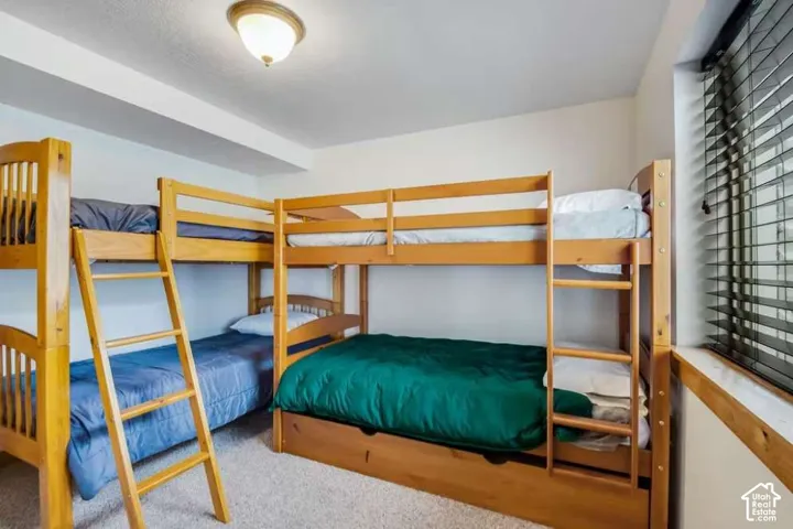 Built-in bunk beds with natural wood finish, window with wood-finish trim, and recessed lighting
