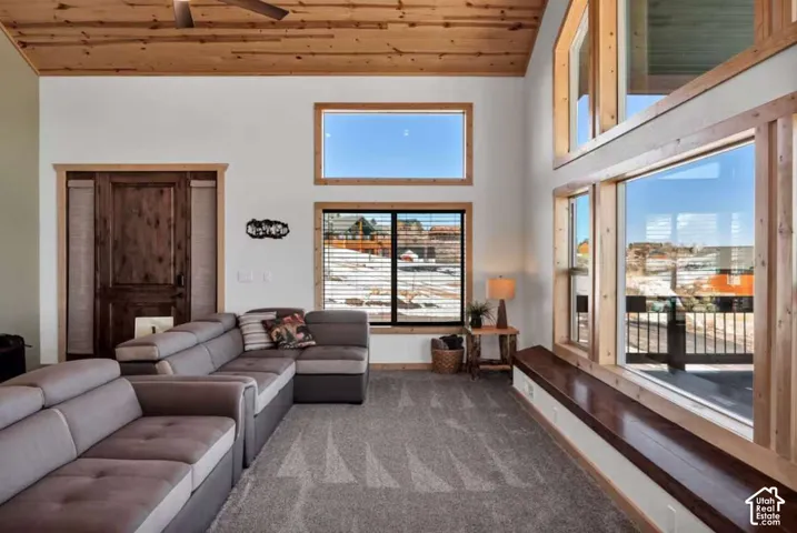 Vaulted wood-paneled ceiling, ceiling fan, wood-framed windows, built-in wood bench, and a wood-finish entry door