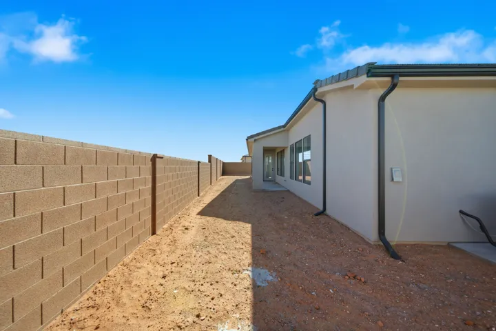 Exterior stucco finish with multiple windows and dark gutters