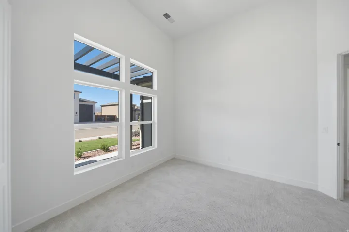 Vaulted ceiling, geometric window design, light-colored carpeting, white wall finishes, crisp white trim work