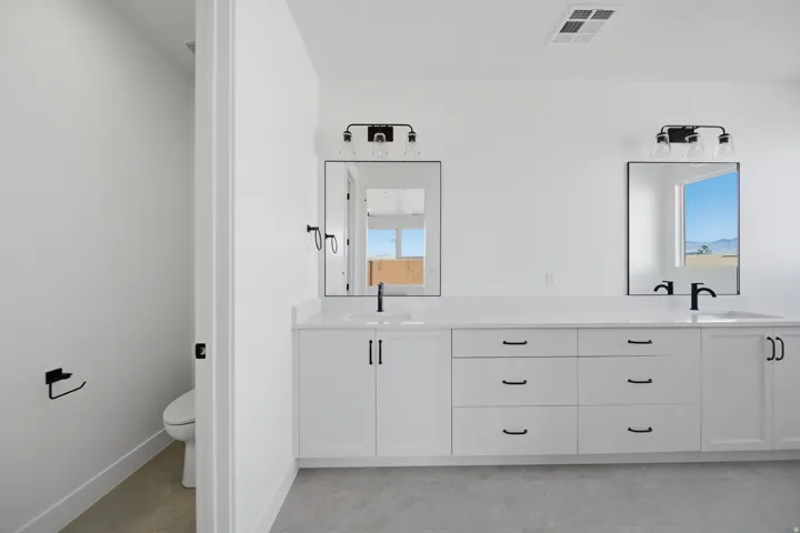 Dual vanity with white cabinetry and black hardware