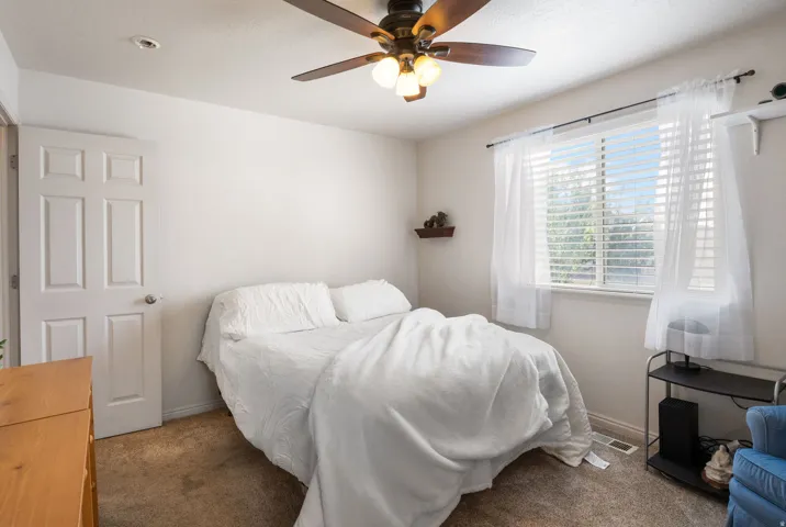 Ceiling fan with integrated lighting, recessed ceiling light, paneled interior door, window with blinds, wall-mounted shelving