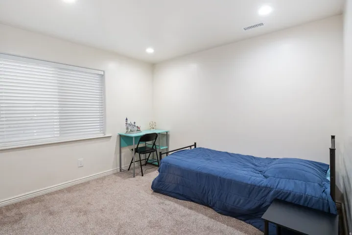 Recessed lighting, window with horizontal blinds, neutral wall paint, and carpeted flooring