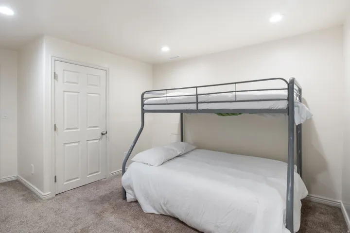 Recessed lighting, light-toned walls, and grey carpeting