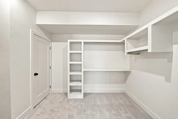 Integrated shelving, built-in desk, wardrobe rod, and white panel door with black hardware