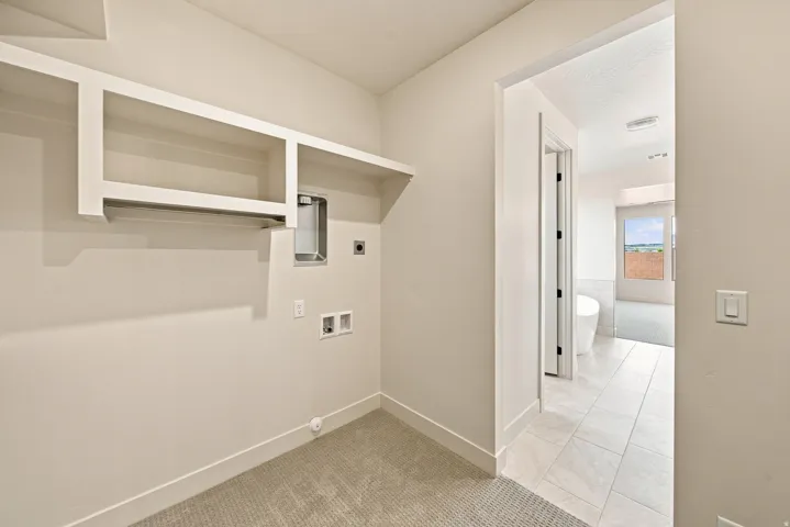 Laundry area with built-in shelving, clothing rod, and carpet flooring