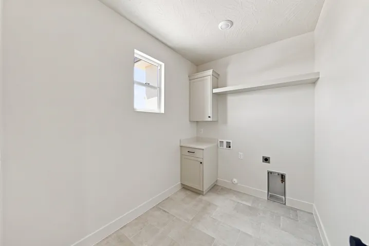 Neutral-toned tile flooring, built-in cabinetry, an integrated shelf, and a window