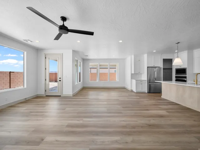 Open-concept living space featuring wood-finish flooring, recessed lighting, and a modern ceiling fan