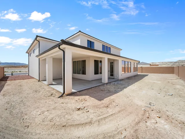 Two-story stucco exterior with a covered patio and a large backyard