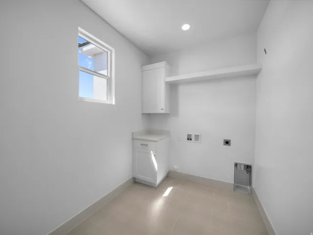 Laundry area featuring a window, recessed lighting, built-in cabinetry, a countertop, and wall shelving