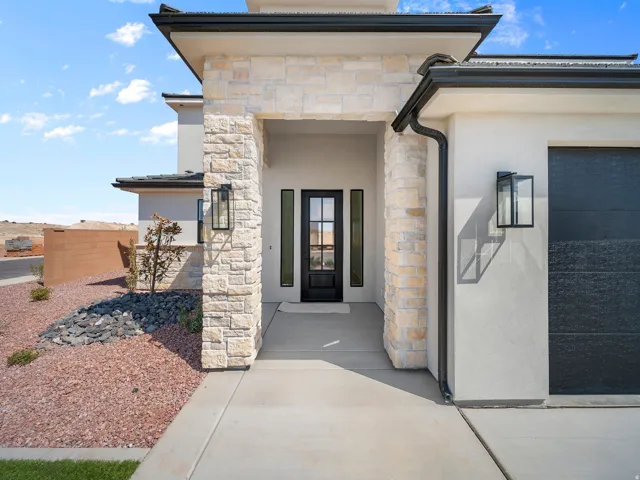 Stone veneer facade with a black paneled front door and sidelight windows